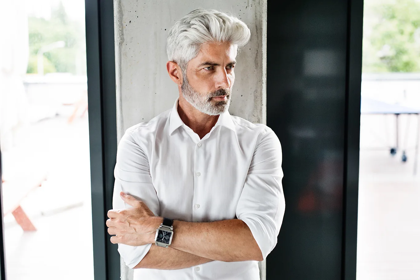 Man with silver hair and a beard, arms crossed